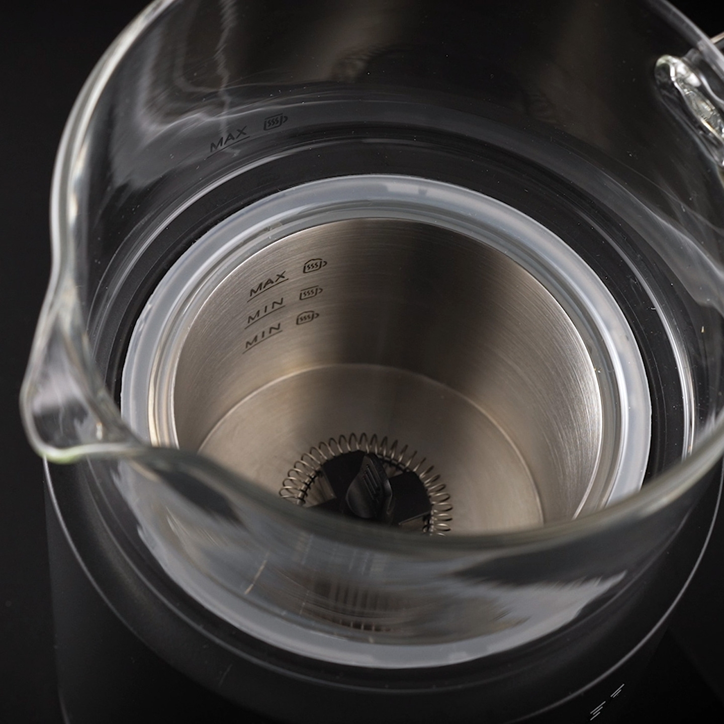 Gros plan d'un récipient en verre avec des marques de mesure maximales et minimales.