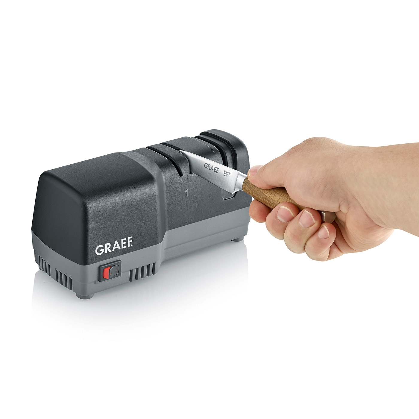 Knife being sharpened with an electric knife sharpener, GRAEF logo visible