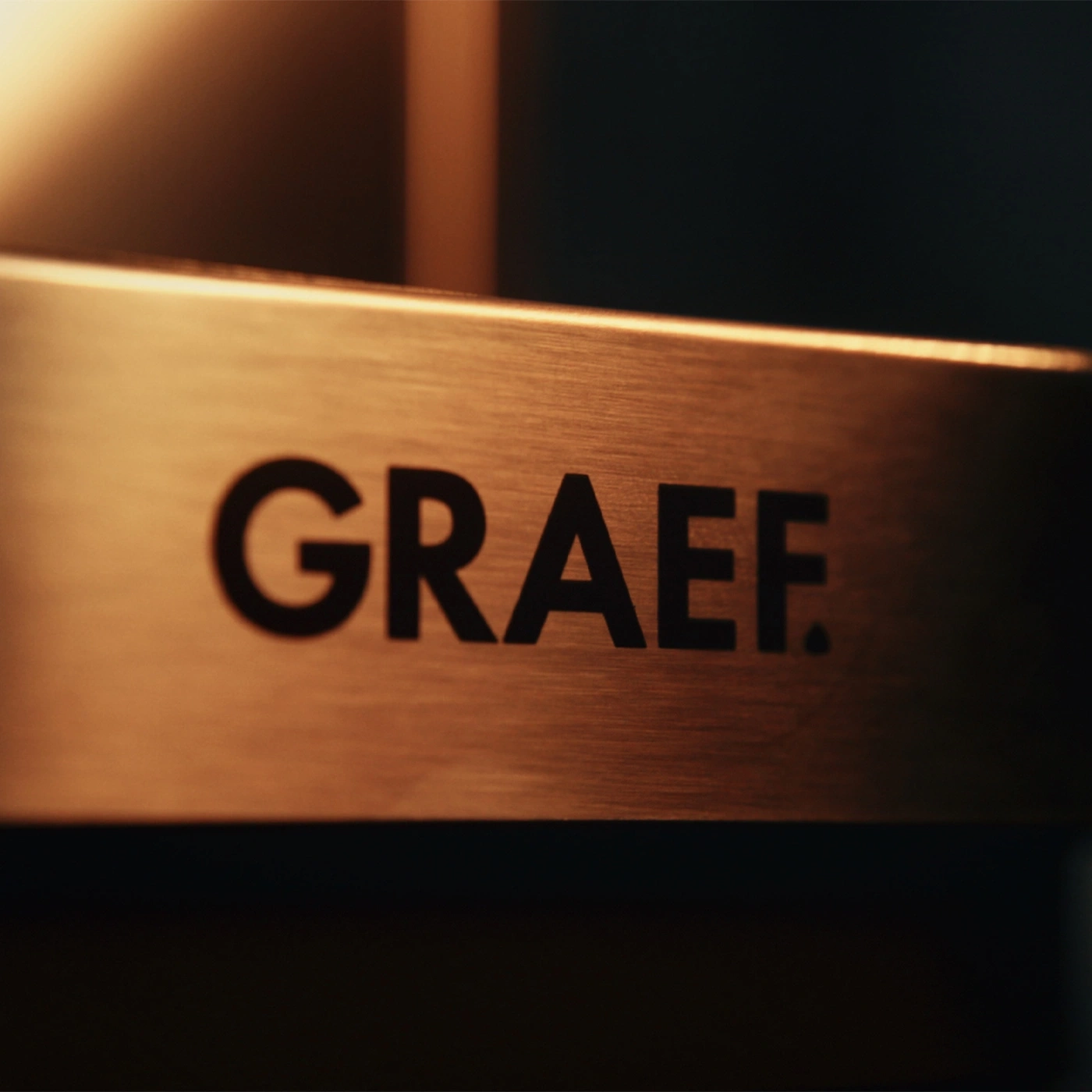 Le logo GRAEF sur une bande métallique brossée.