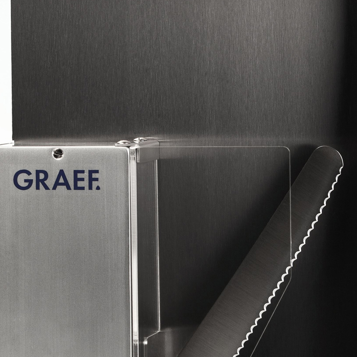 Graef logo on metal surface with serrated knife and dark background