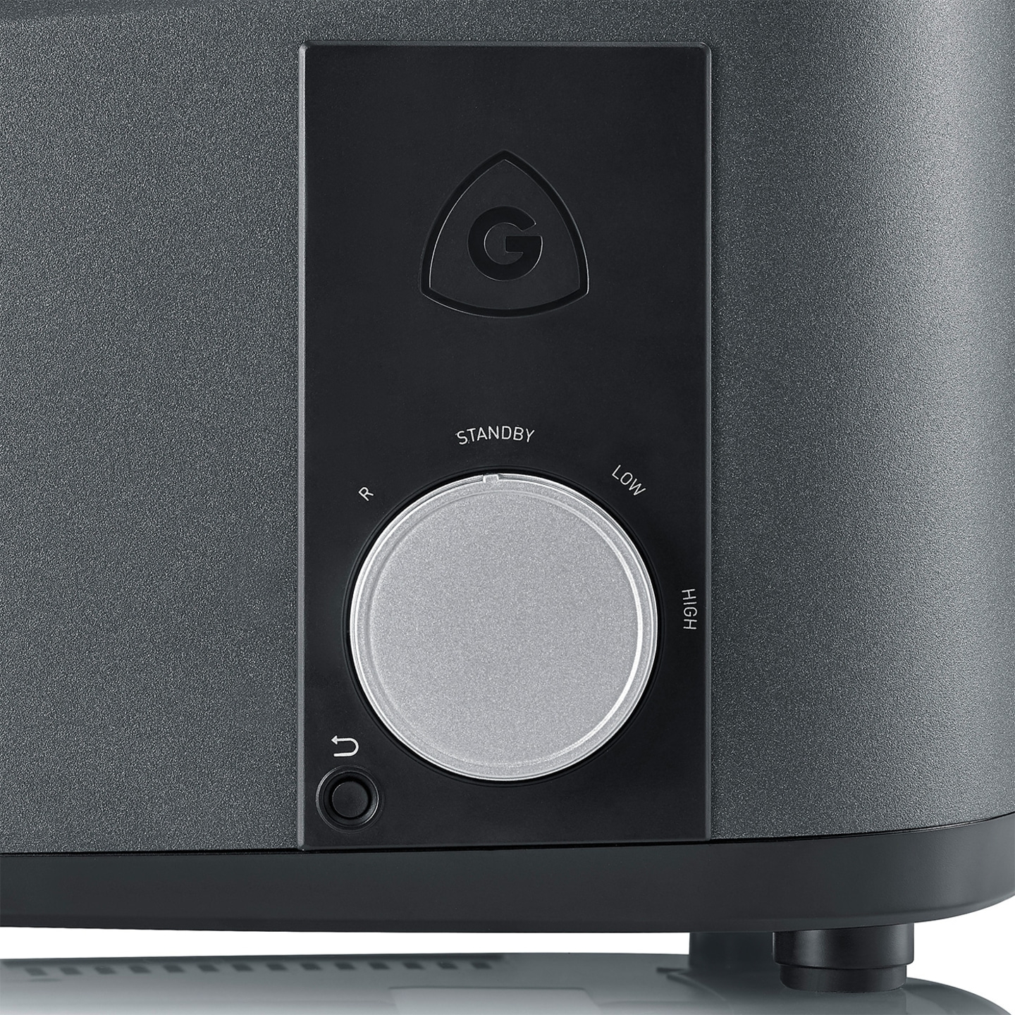 Close-up of a device with a dial and logo. Black and gray color scheme.