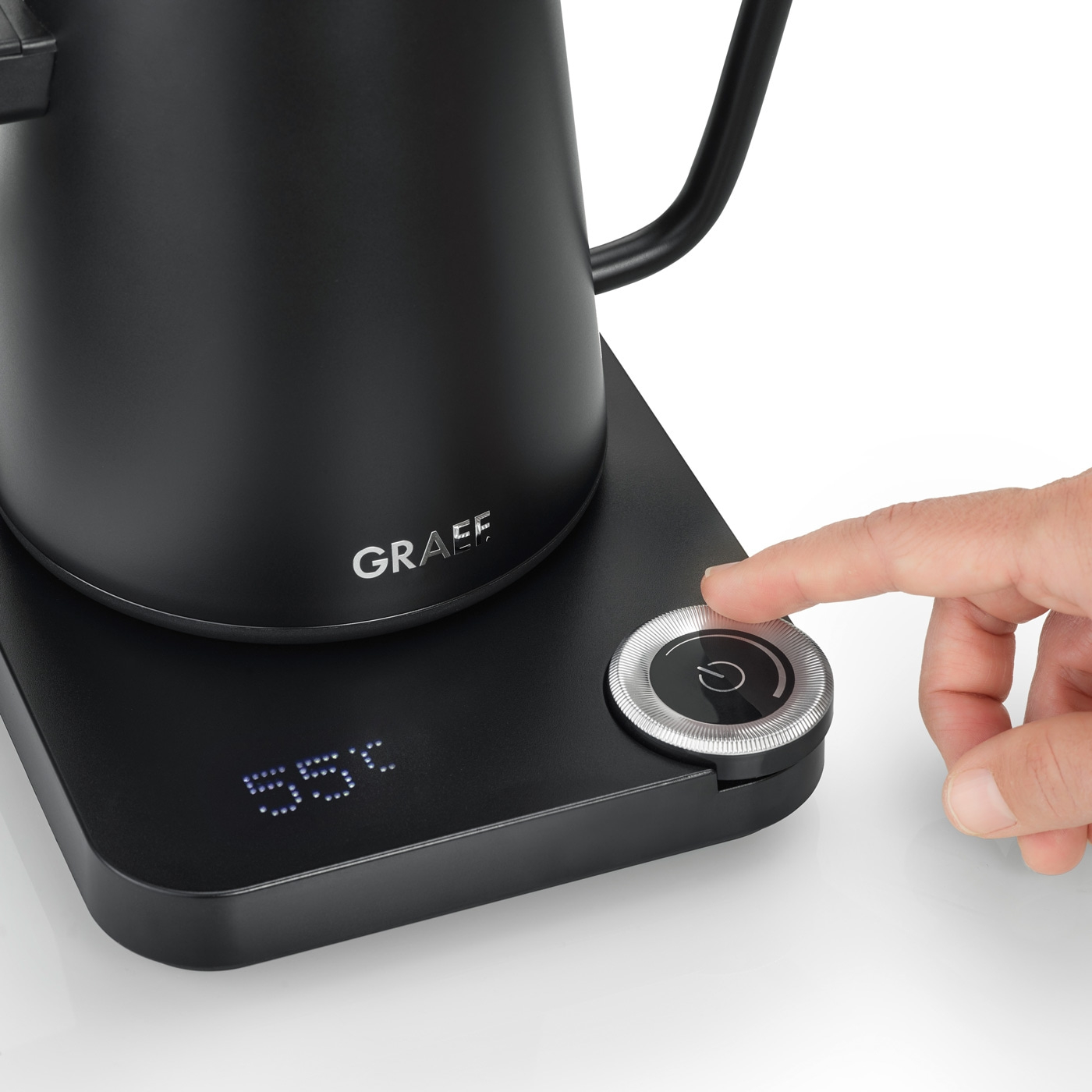 Black kettle with temperature display and control knob, finger touching the knob.