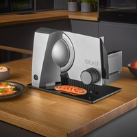 Graef slicer with tomato slices on wooden surface and bread