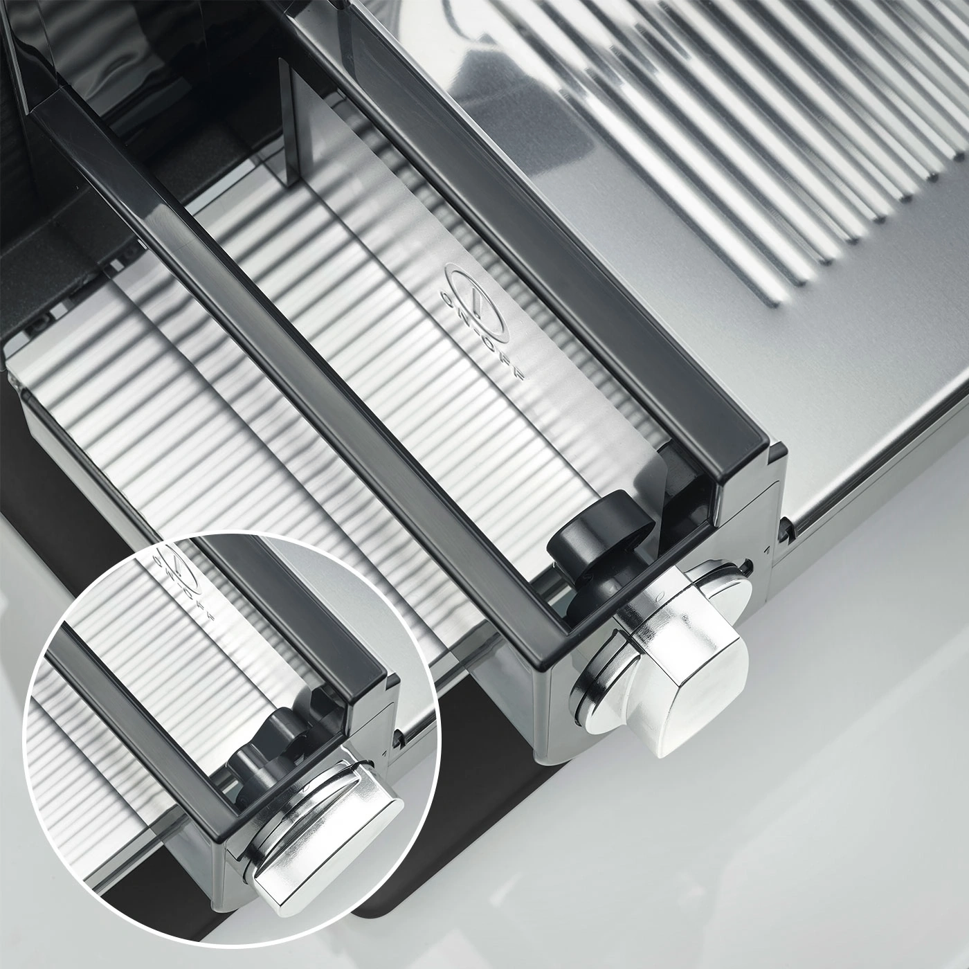 Close-up of a silver meat slicer with knobs and intricate details