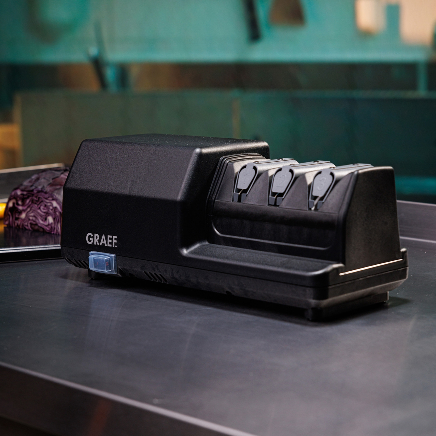 Affilacoltelli elettrico nero con logo GRAEF su una superficie metallica, primo piano.