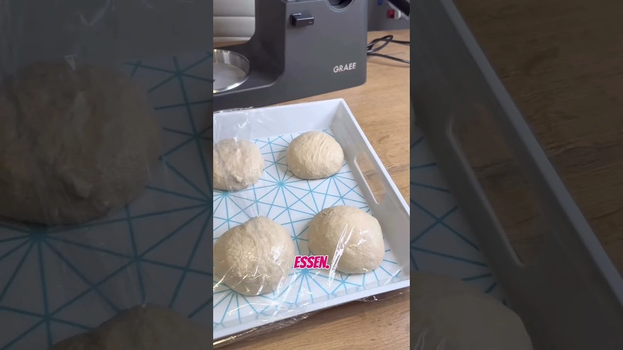 Boules de pâte dans un plateau recouvert d'une pellicule plastique, appareil GRAEF en arrière-plan.