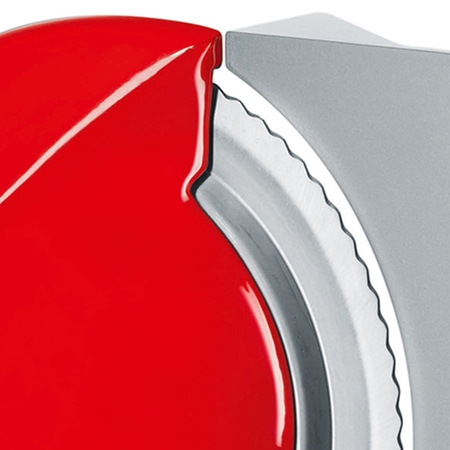 Close-up of a red object with a serrated metal part, sharp and shiny