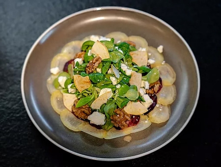 Salad with pear, walnut, cheese and greens on a plate