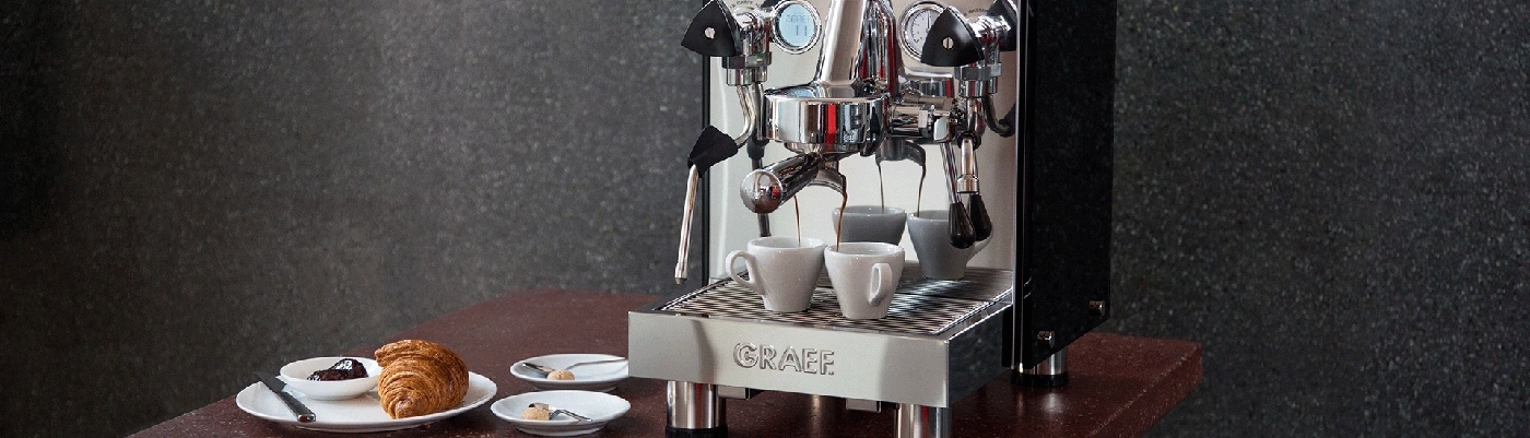 Macchina da caffè con croissant e pasticcini su un tavolo