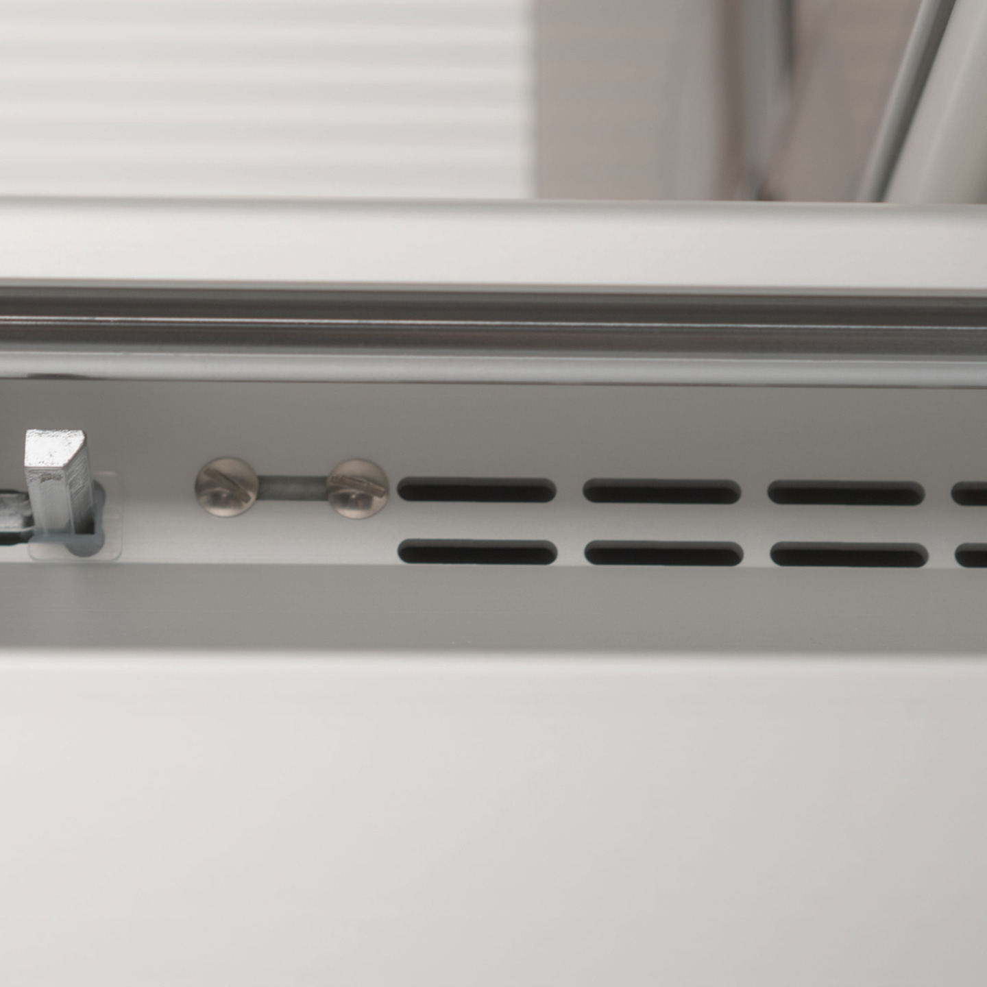 Close-up of metal with screws and slots, detail shot, gray color, industrial