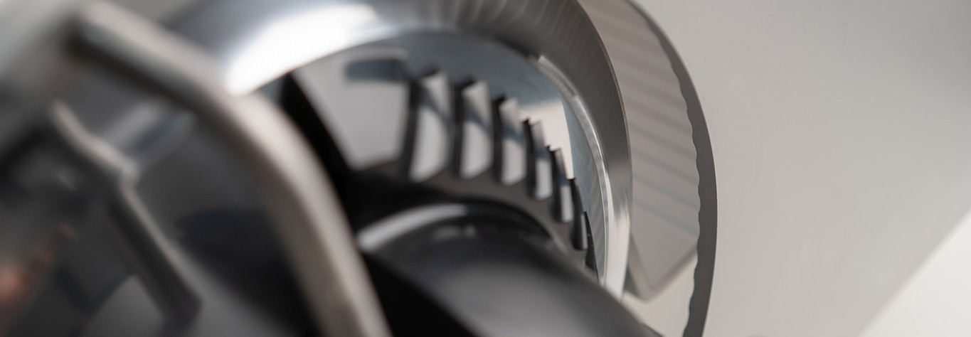 Close-up of a metal part with teeth and a smooth, reflective surface