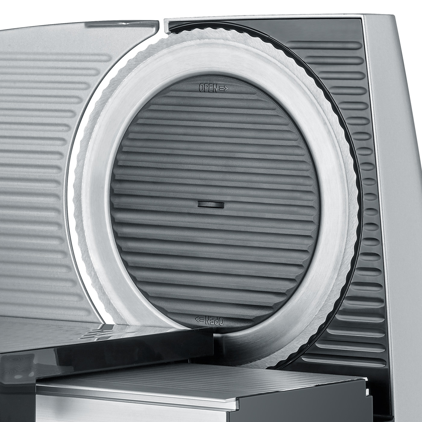 Primo piano di un'affettatrice d'argento con una lama circolare e la scritta "OPEN".