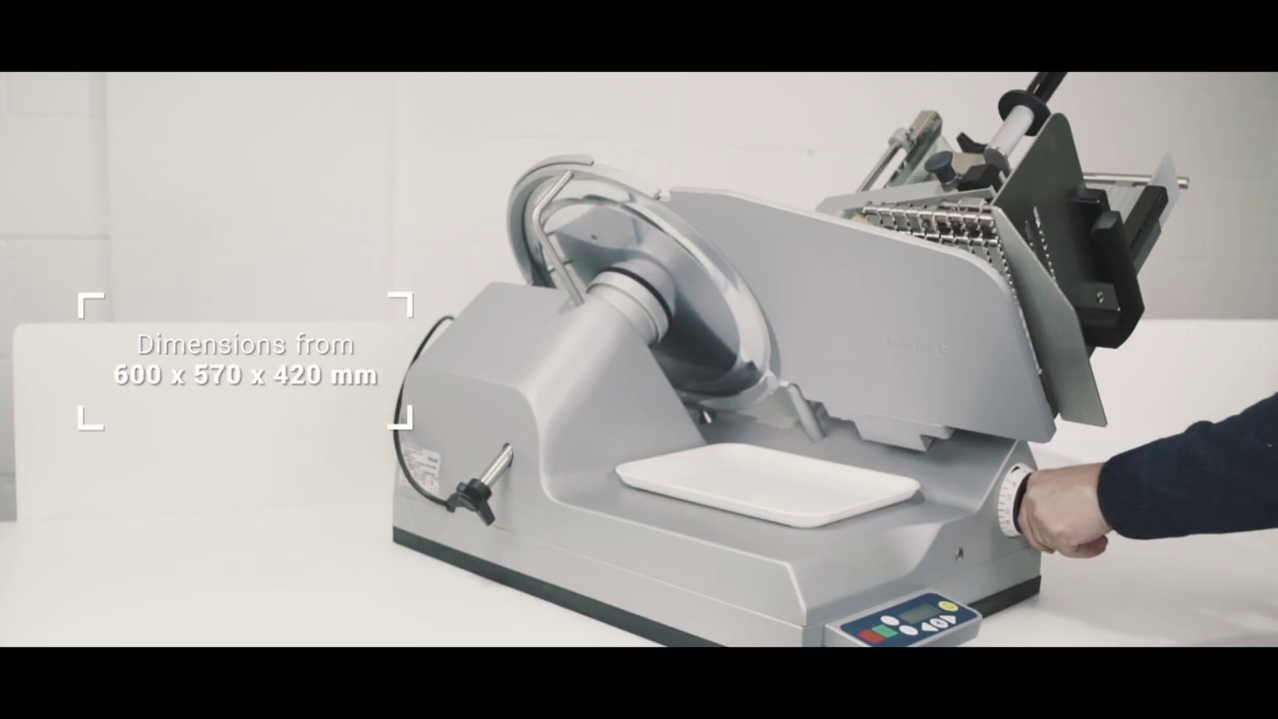 Affettatrice con dimensioni di 600 x 570 x 420 mm, colore grigio, vassoio bianco.