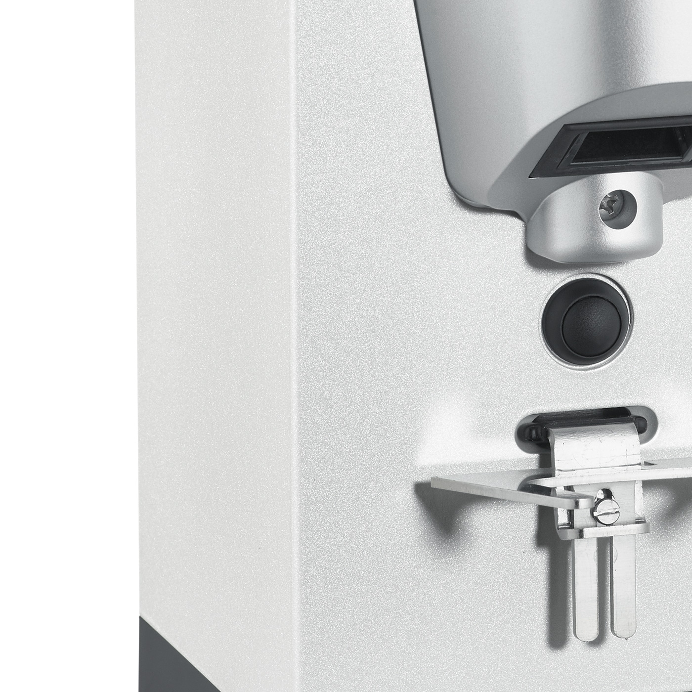 Gros plan d'un appareil argenté avec un bouton et des pièces métalliques.