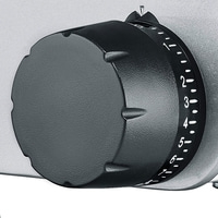 Primo piano di una manopola nera con numeri su sfondo argentato.