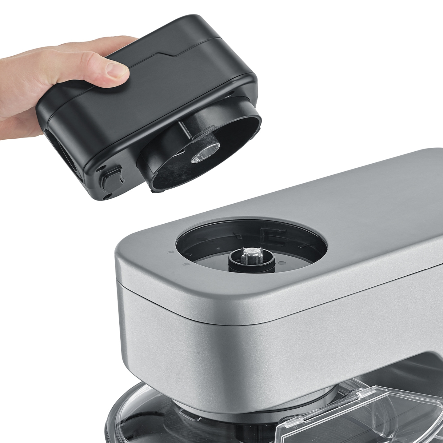 Main tenant un appareil noir au-dessus d'un appareil argenté pour les connecter.