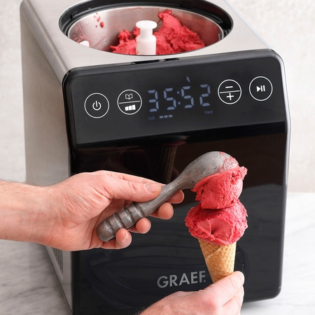 Ice cream machine scooping ice cream into a waffle cone.