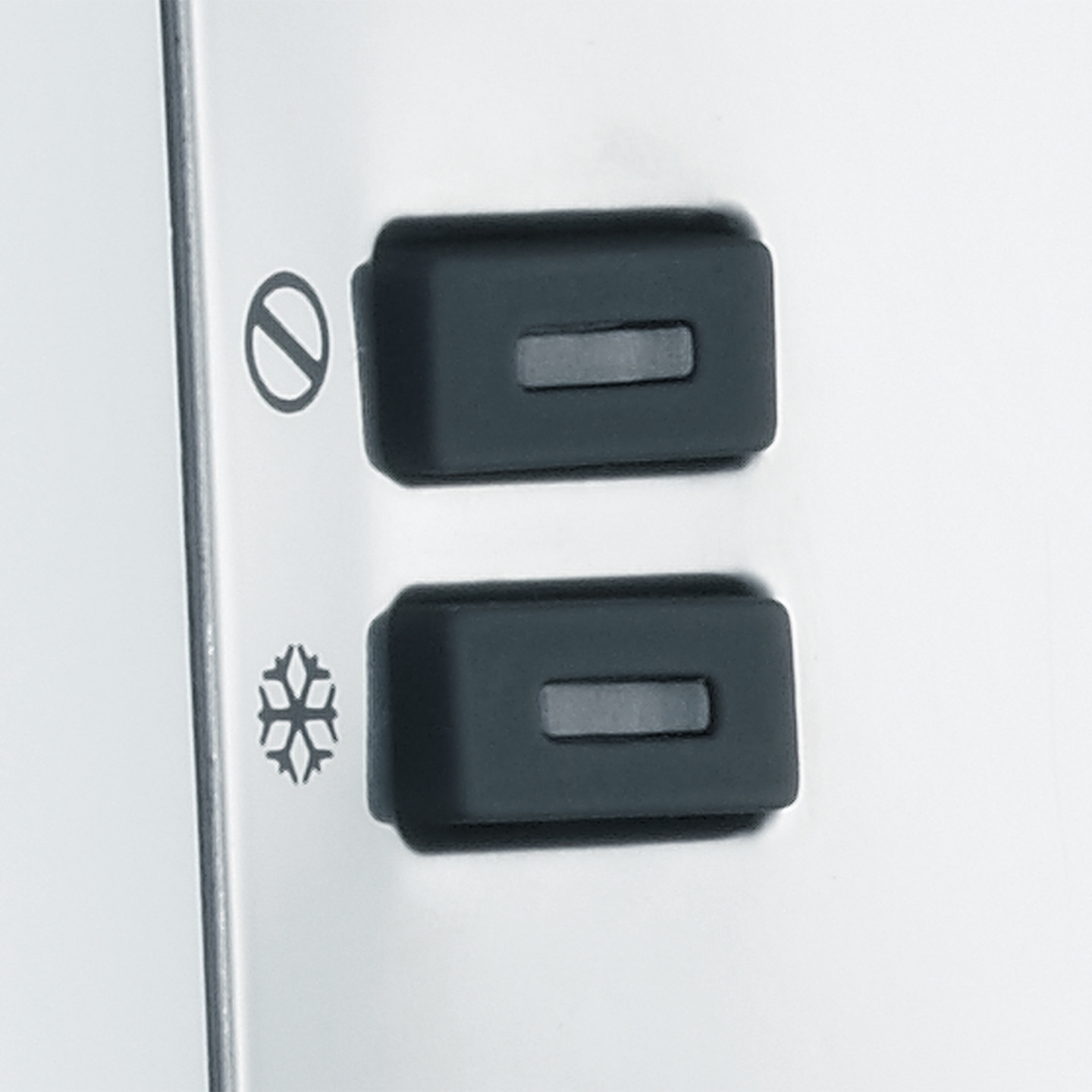 Deux boutons noirs avec des symboles sur une surface blanche, gros plan, commandes d'appareil.