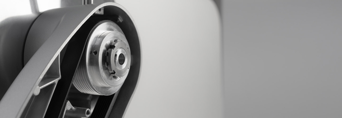 Close-up of a metallic belt drive with a gear and a belt in a machine