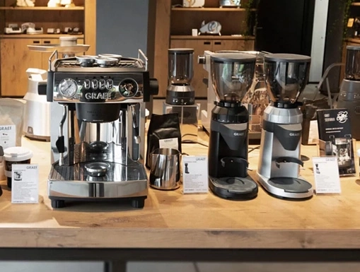 Machine à café et moulins à café sur une table en bois dans un magasin