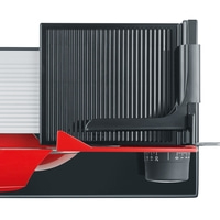 Close-up of a food slicer with red and black parts and a dial.