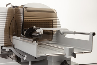 Trancheuse à viande grise avec protection, gros plan, isolé sur fond blanc