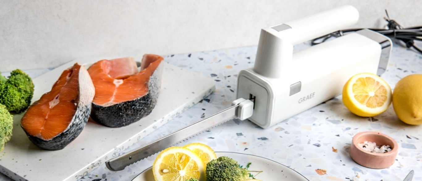 Lachsfilet mit Zitrone und Brokkoli, serviert mit einem elektrischen Messer.