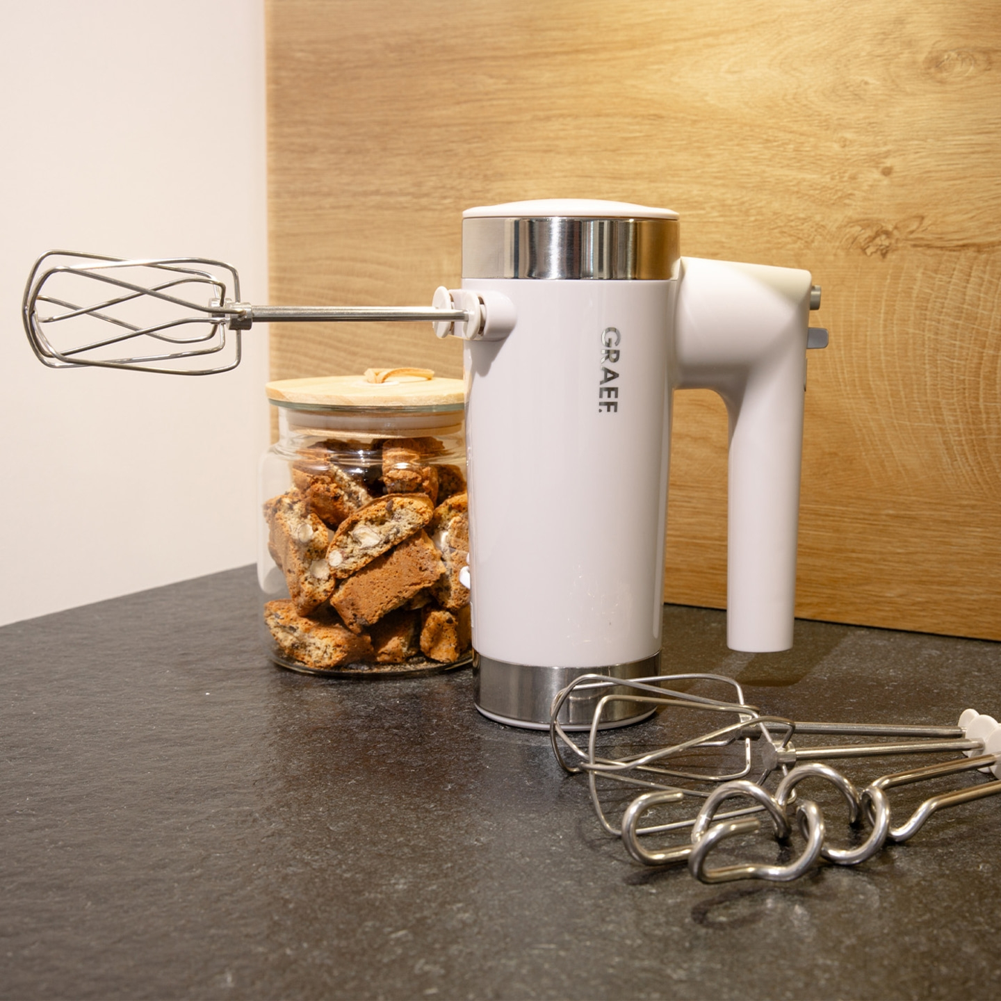 Mixeur plongeant avec accessoires et biscuits dans un bocal sur un comptoir