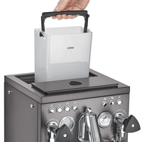 Persona che solleva il serbatoio dell'acqua dalla macchina da caffè, primo piano.