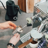 Personne préparant du café, mousse de lait, machine à expresso, bouilloire, mains, tasse