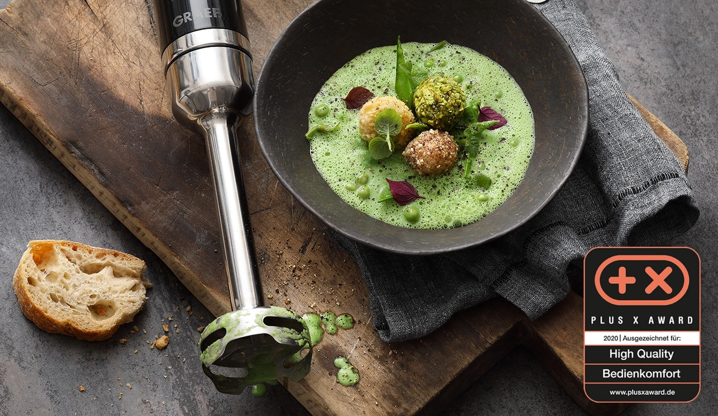 Soupe aux herbes et pain, à côté d'un mixeur plongeant, récompensé par le Plus X Award.