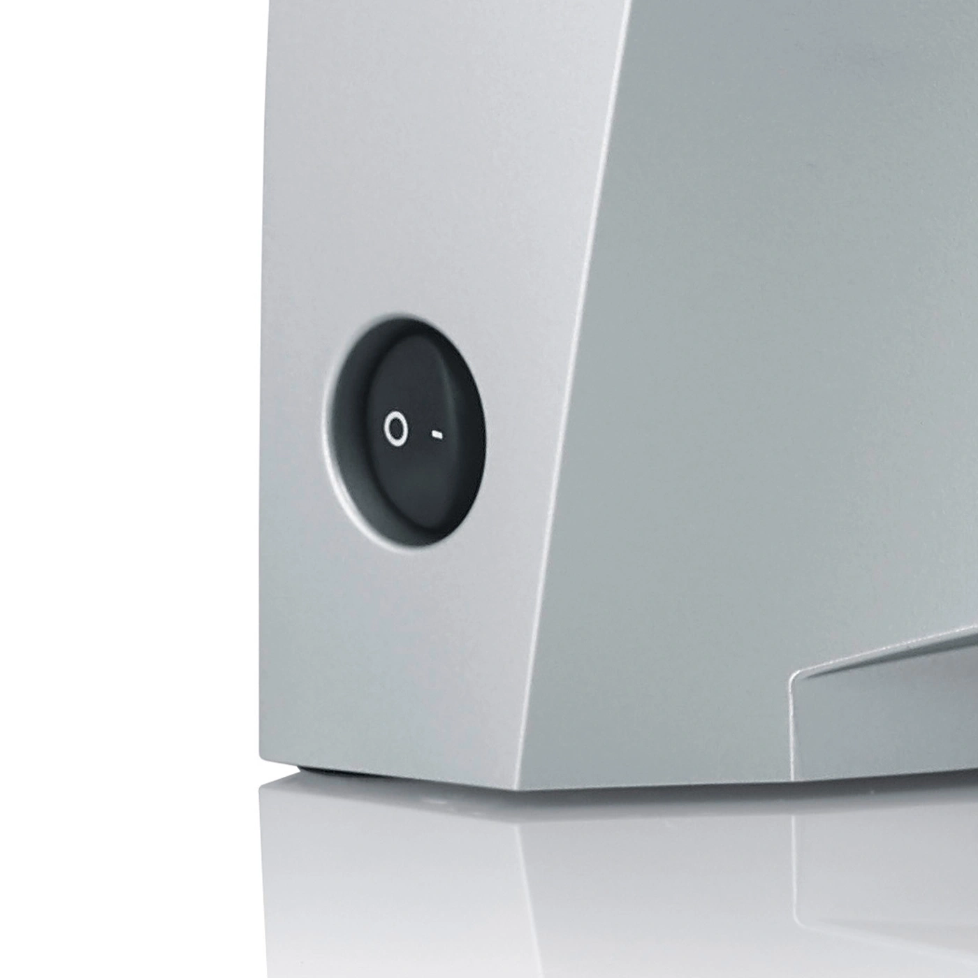 Close-up of a gray device with a round on-off switch, detail shot