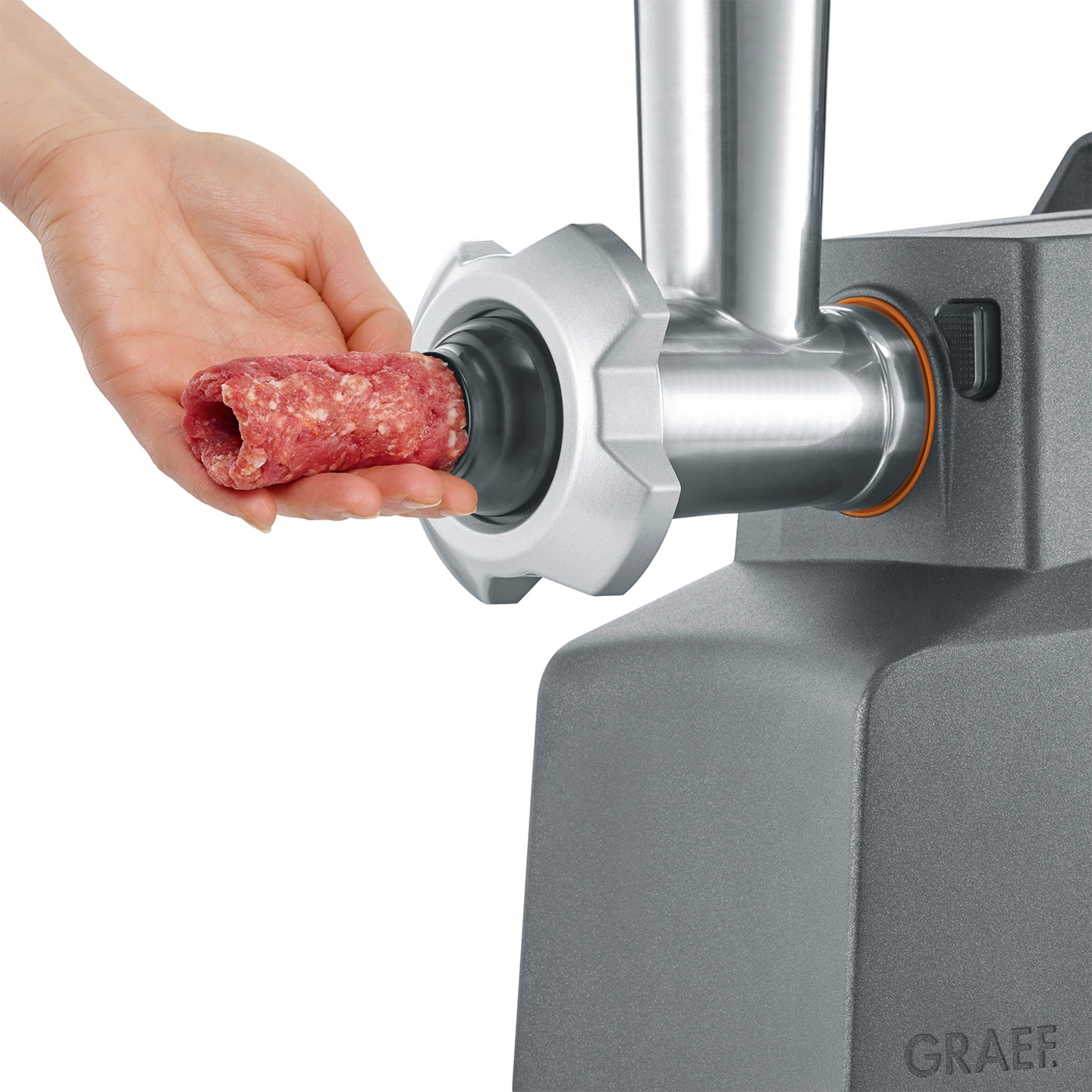 Meat grinder with meat. Hand holding meat. Graef logo. Close-up. Meat being processed.