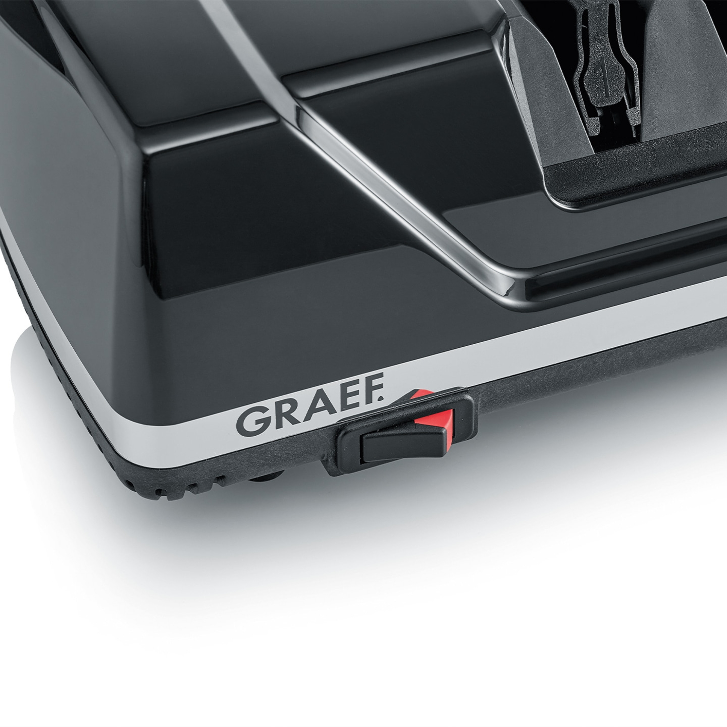 Close-up of a black device with GRAEF logo and red switch, shiny surface.