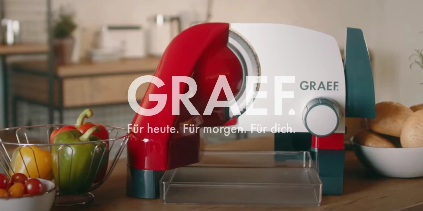 Affettatrice Graef con verdure e panini in cucina