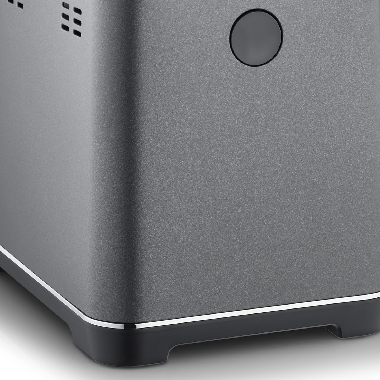 Close-up of a gray device with a button and vents, modern design, smooth surface, detail shot