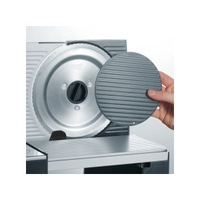 Gros plan d'une trancheuse à viande avec un dispositif de protection et une main