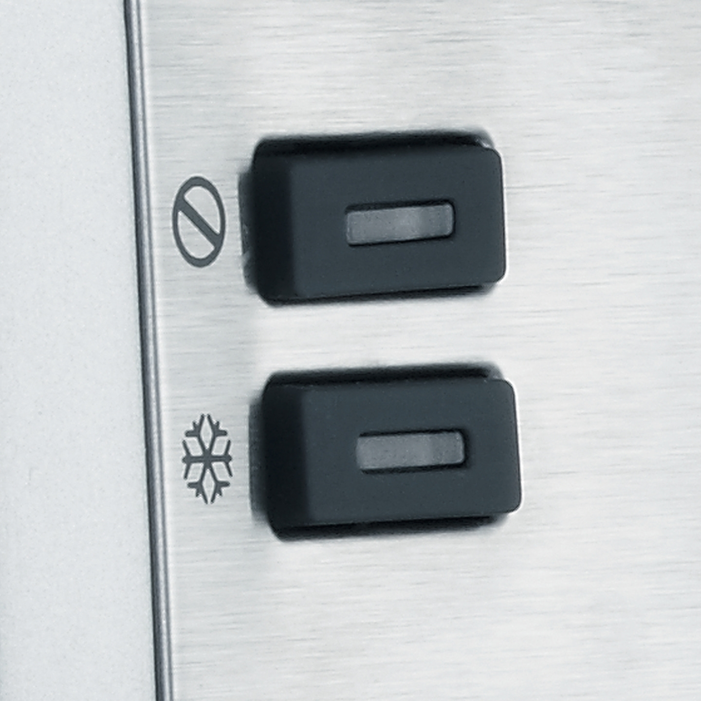 Two black buttons with symbols on a metallic surface, close-up shot.