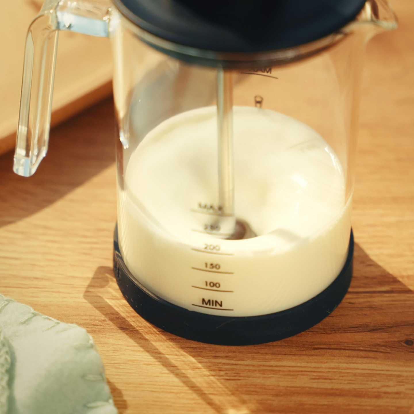 Mousseur à lait avec du lait sur une table en bois