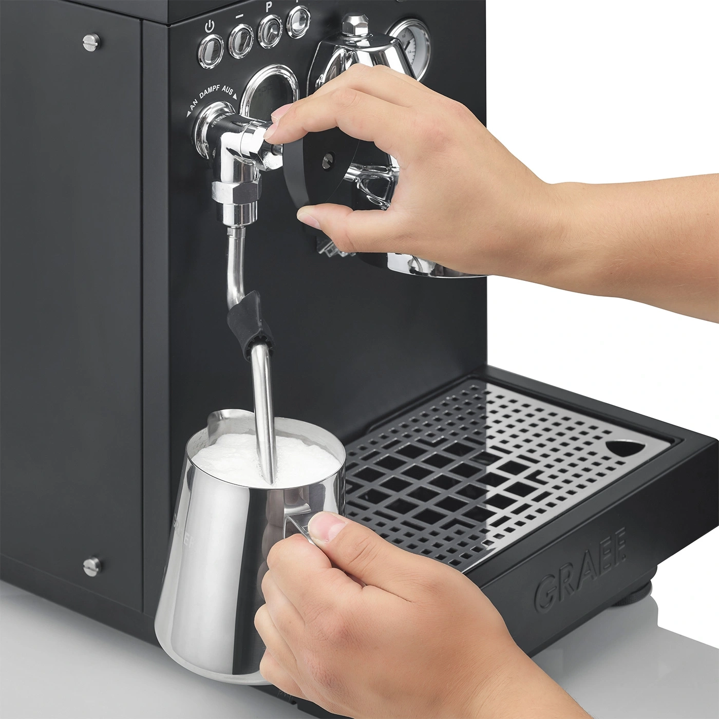 Persona che monta il latte con una macchina per espresso per fare il caffè.