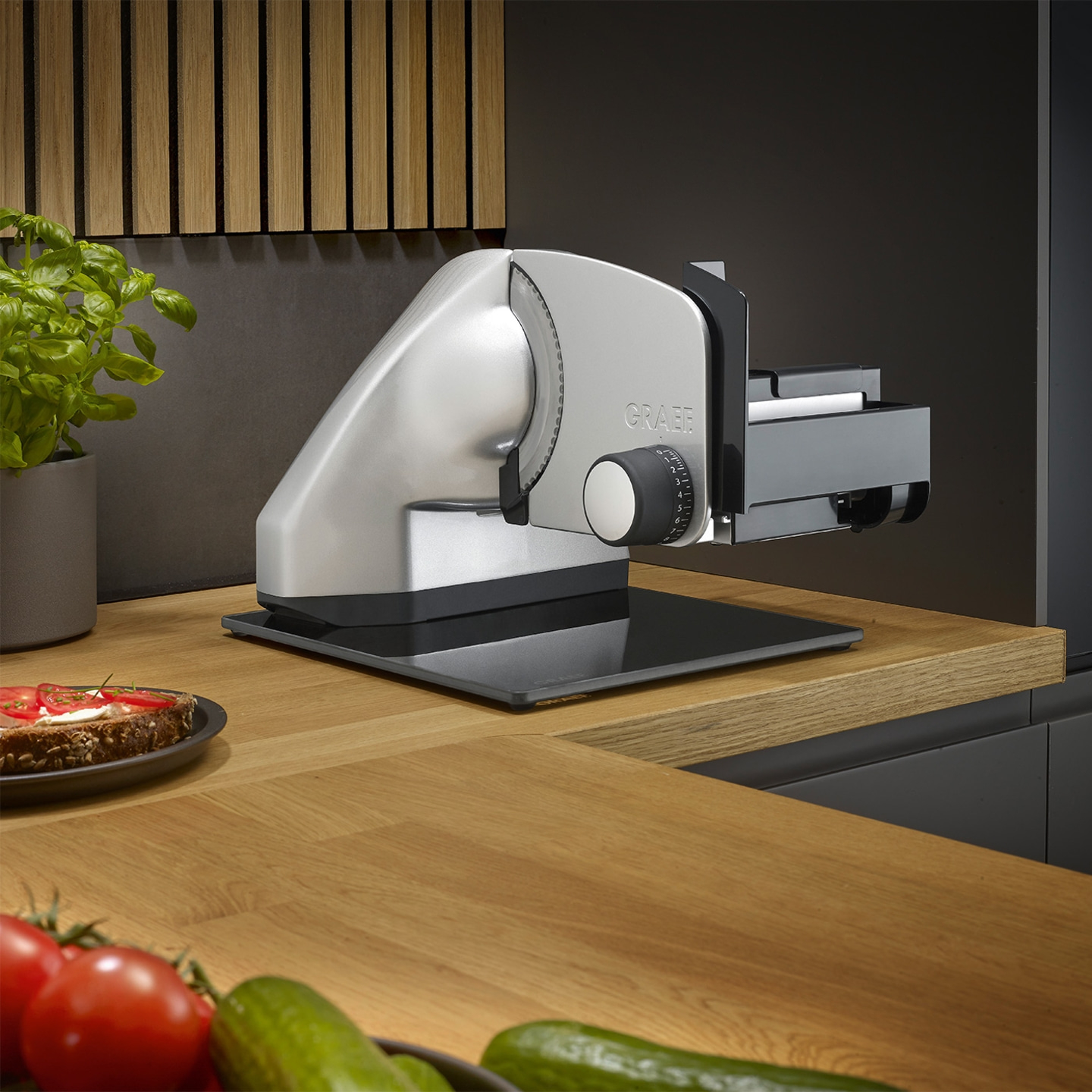 Graef slicer on wooden table with vegetables and bread in the foreground