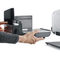 Affettatrice Graef smontata, mani che tengono pezzi, dettaglio, grigio