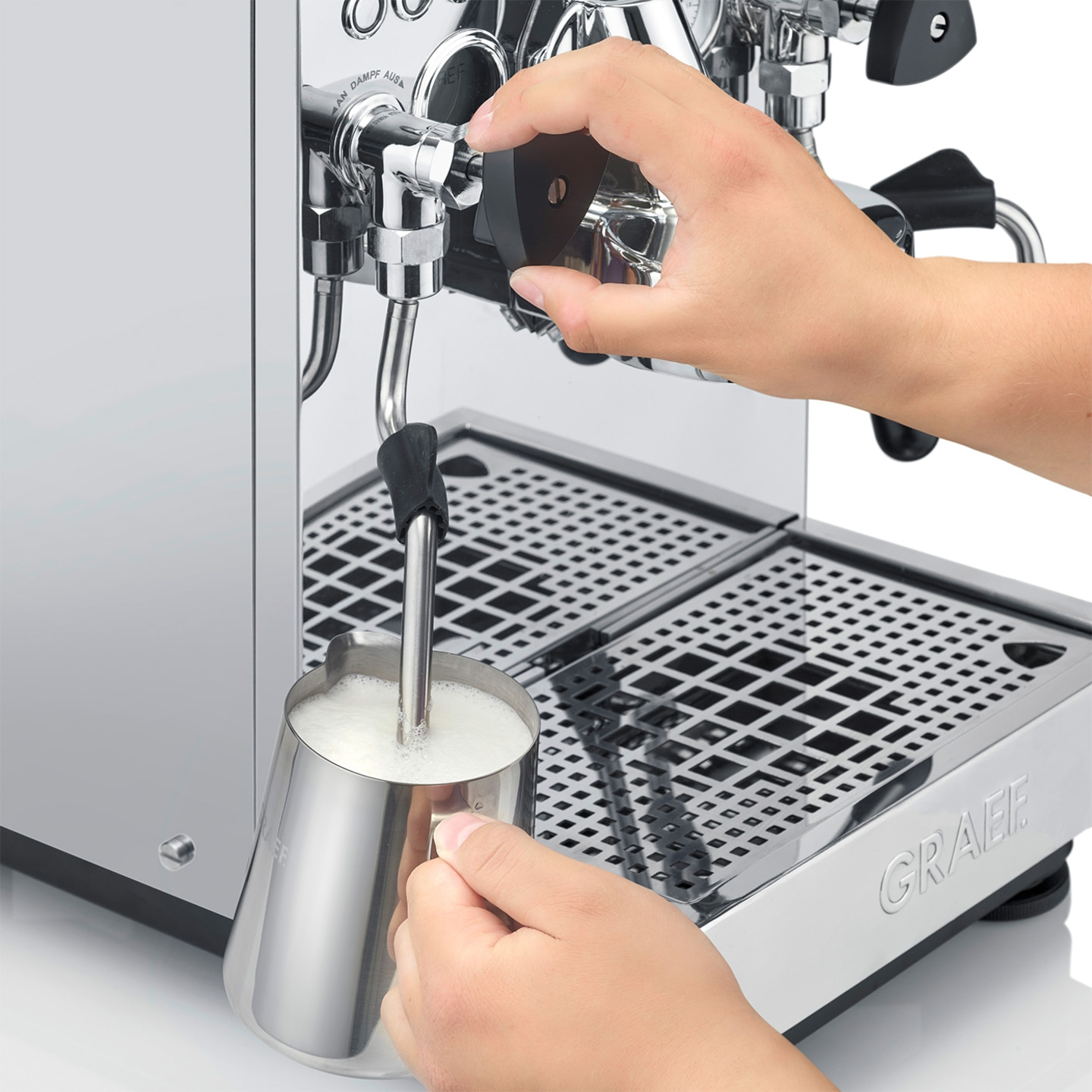 Persona che monta il latte con una macchina per espresso per fare un latte.