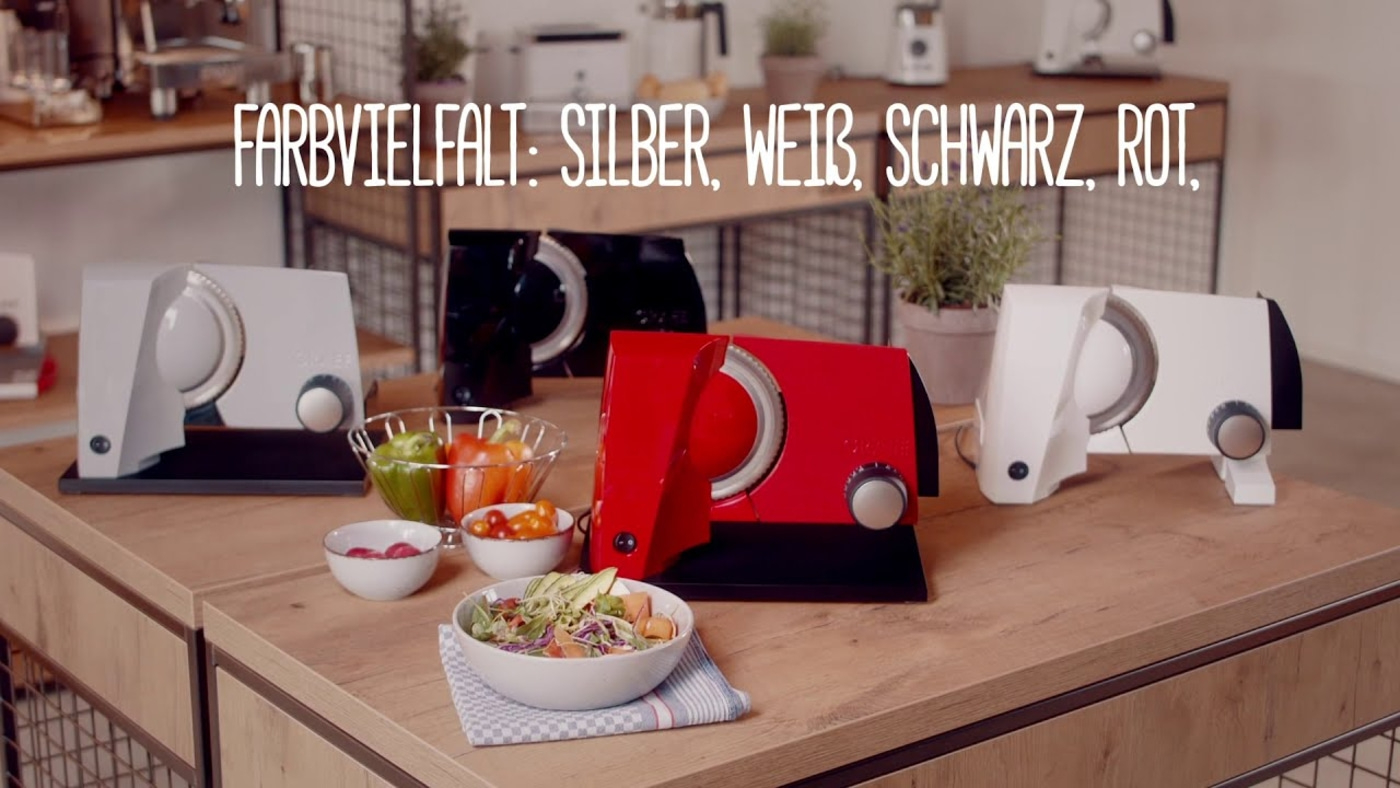 Trancheuses à légumes en argent, blanc, noir et rouge sur une table en bois. Variété de couleurs.