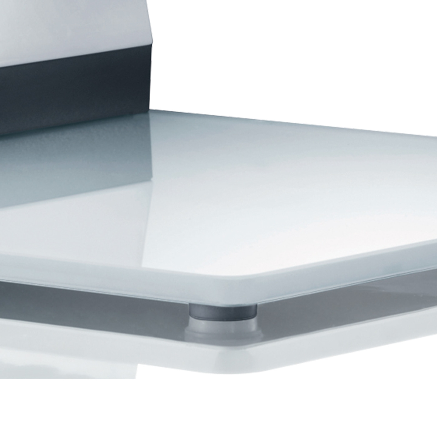 Gros plan d'une étagère en verre avec un bord sombre et des supports argentés.