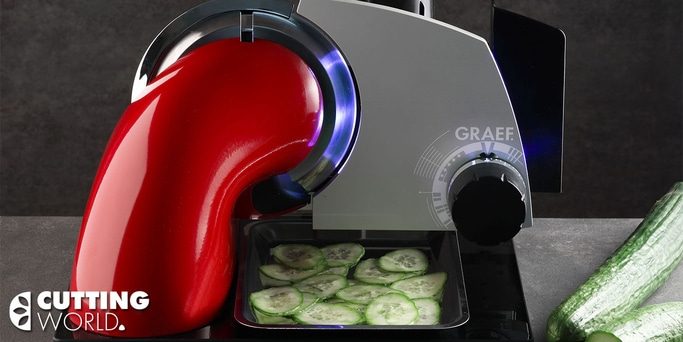 Vegetable slicer with cucumbers being sliced on a table, cutting world logo