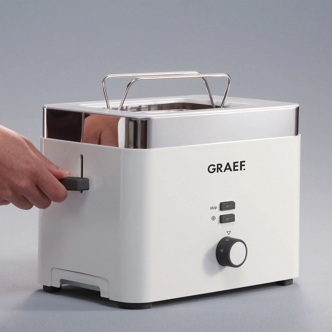White toaster with control buttons and a metal handle, featuring the GRAEF logo.