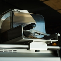 Primo piano di un'affettatrice con protezione e maniglia