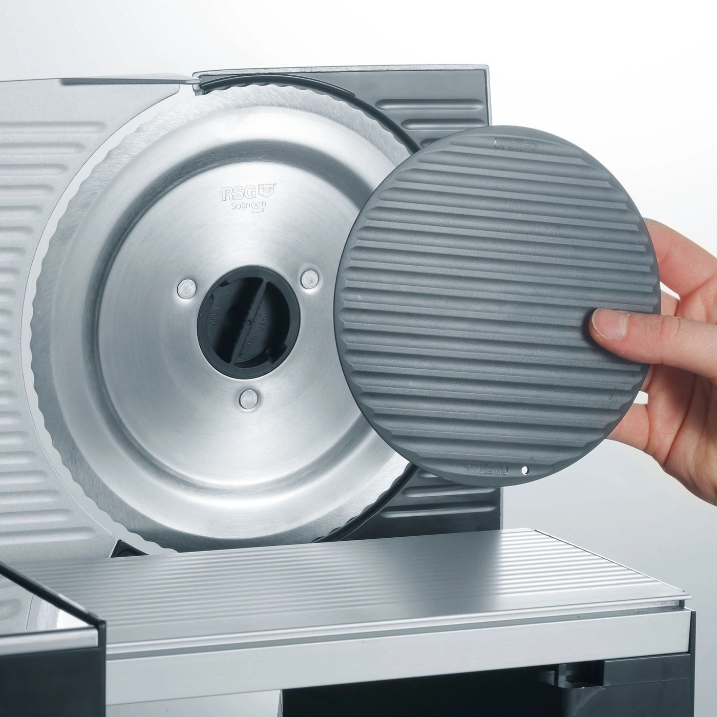 Close-up of a meat slicer with a protective device and stainless steel blade