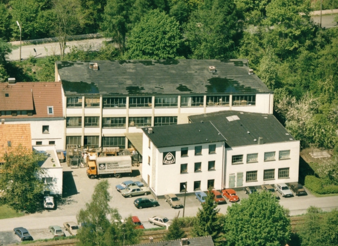 Vue aérienne de bâtiments avec des arbres et des voitures garées à proximité.